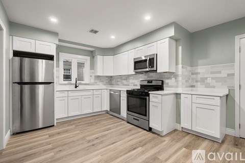 A modern kitchen with white cabinets and stainless steel appliances.