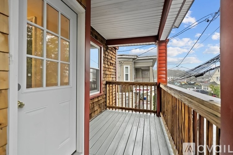A balcony with a white door and wooden floor.