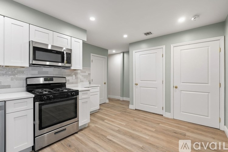 A kitchen with white cabinets and a stainless steel oven.