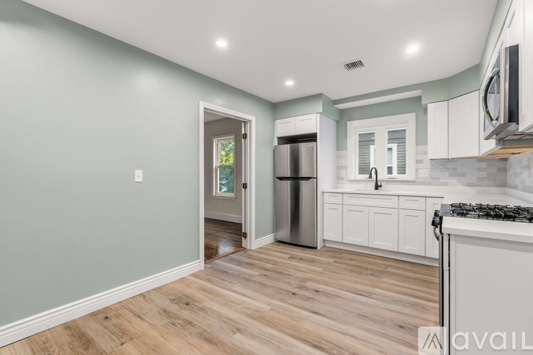 A kitchen with a refrigerator, stove, and cabinets.