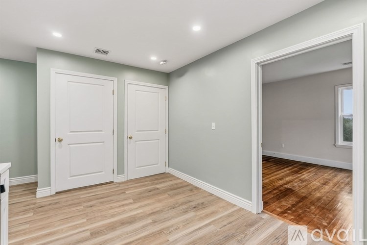 A room with two doors and a mirror on the wall.