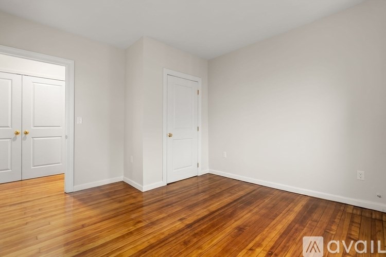 A room with wooden floors and two white doors.