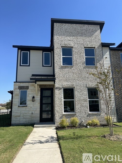 A two-story house with a stone facade and a black door.