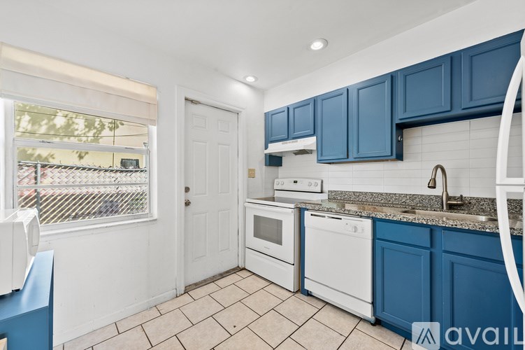 A kitchen with white appliances and blue cabinets.