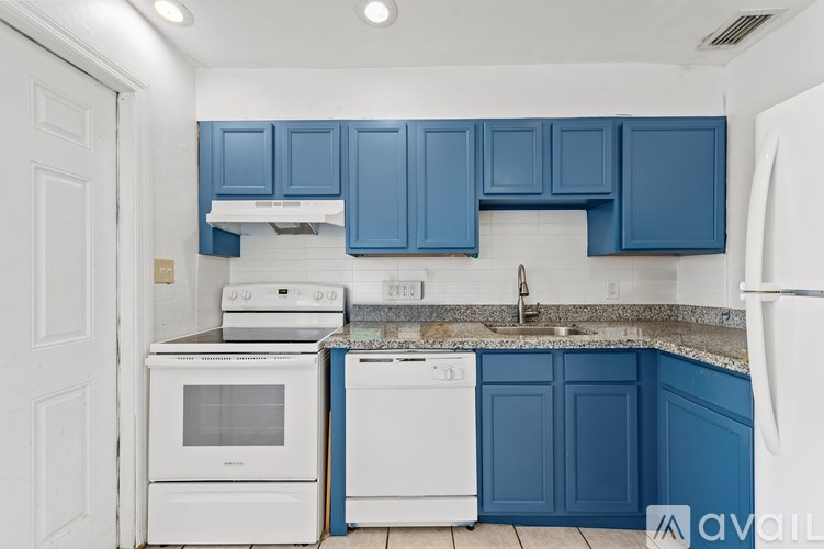 A kitchen with white appliances and blue cabinets.