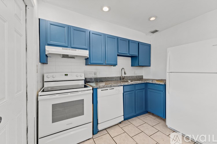 A kitchen with white appliances and blue cabinets.