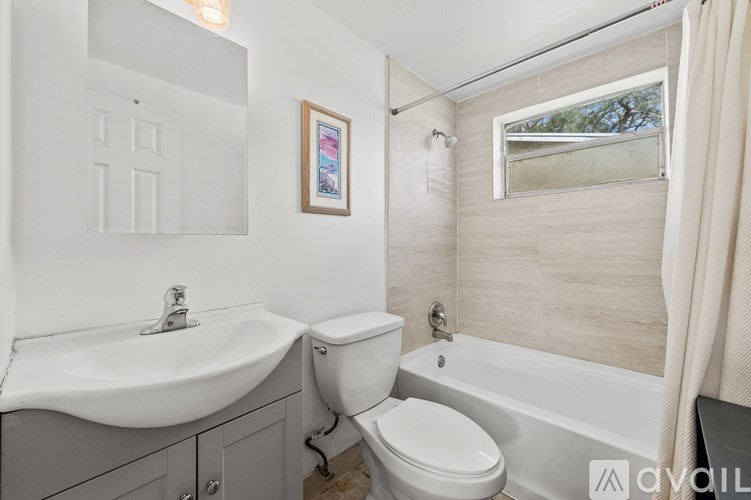 A bathroom with a white sink, toilet, and bathtub.