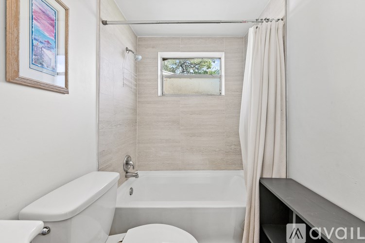 A bathroom with a white tub, toilet, and sink.