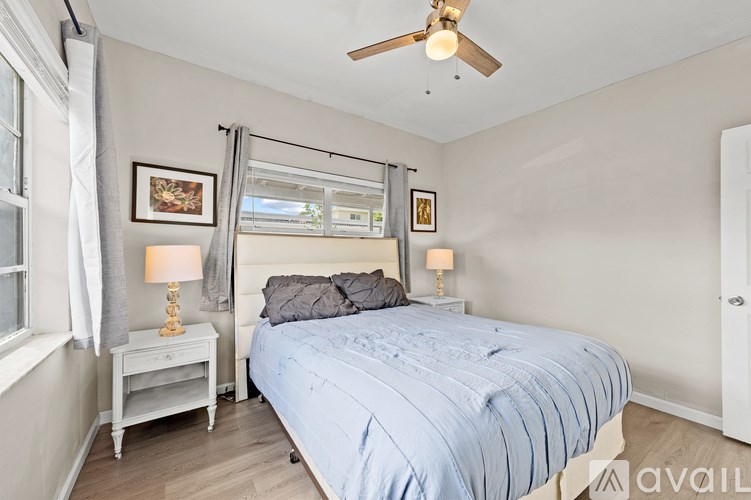 A bedroom with a bed, nightstand, and window.