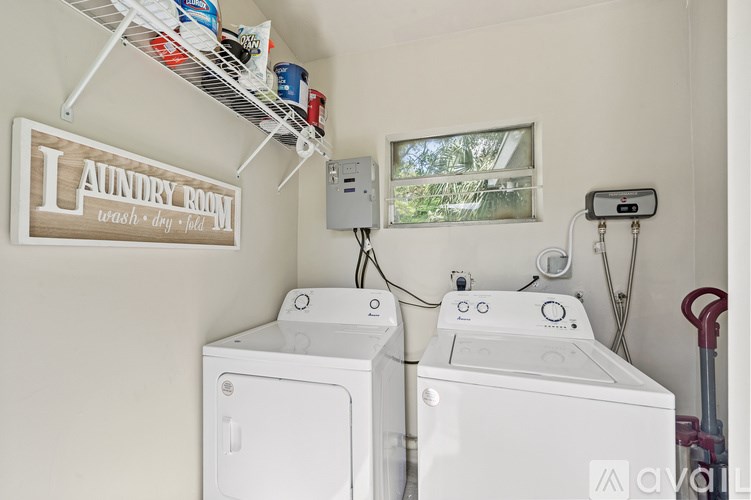 A laundry room with two washing machines and a clothes dryer.