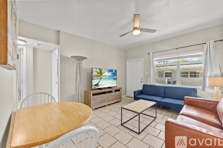 A living room with a television, a blue couch, and a wooden table.