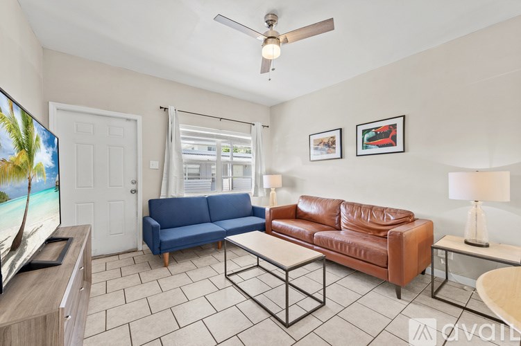 A living room with a blue sofa and a brown leather couch.