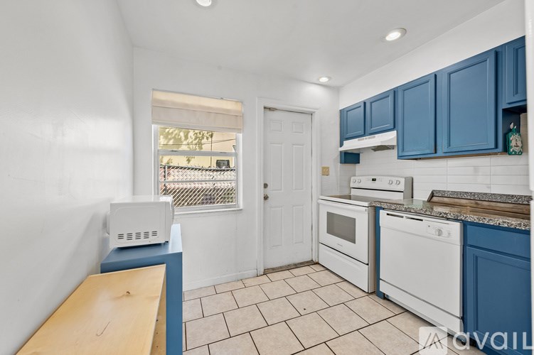 A kitchen with white appliances and blue cabinets.