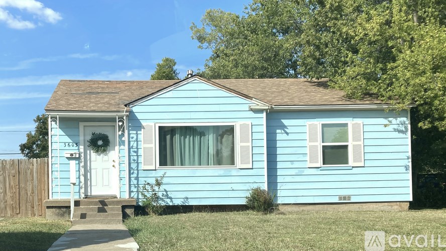 A blue house with a white door and a wreath on it.