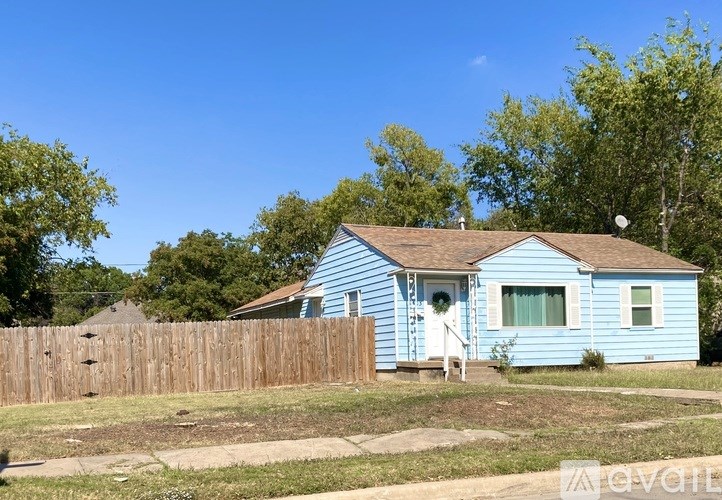 A blue house with a white door and windows.