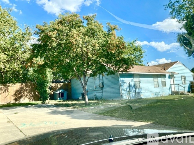 A blue house with a tree in front of it.