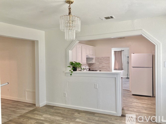 A kitchen with a white counter and a pink refrigerator.