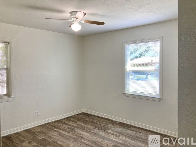 A room with a ceiling fan and a window with blinds.