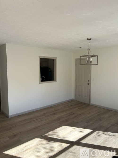 A room with wooden floors and a chandelier.