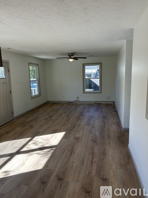 A room with wooden floors and a ceiling fan.