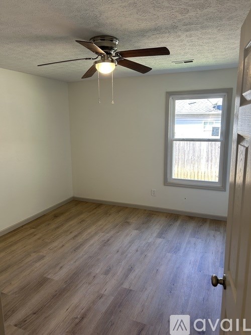 A room with a ceiling fan and a window.