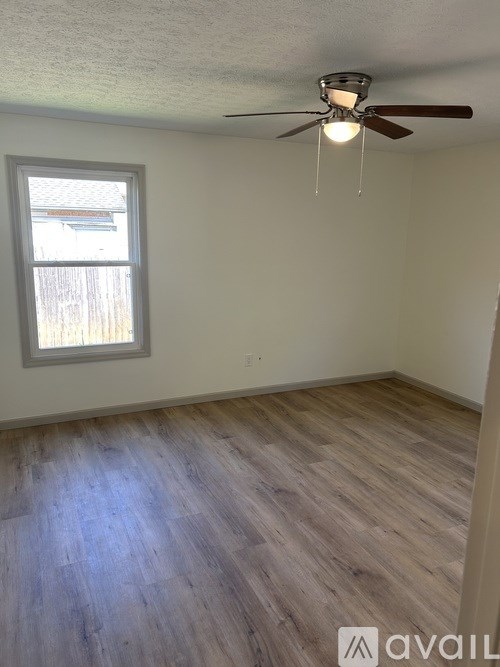 A room with a ceiling fan and a window.