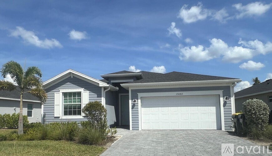 A house with a garage and a driveway in front of it.