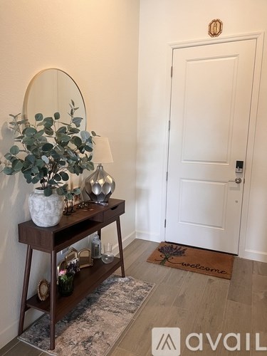 A white door is on the right and a brown shelf with a plant on it is on the left.