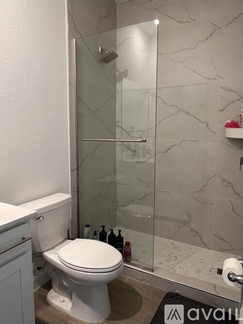 A white toilet in a bathroom with a glass shower door.