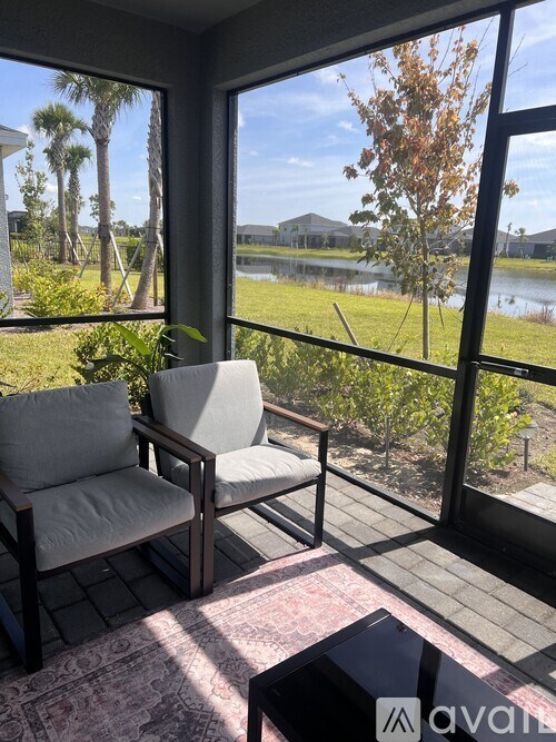 A patio with a chair and a table with a view of a lake.