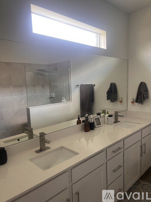 A bathroom with a large mirror and a sink.