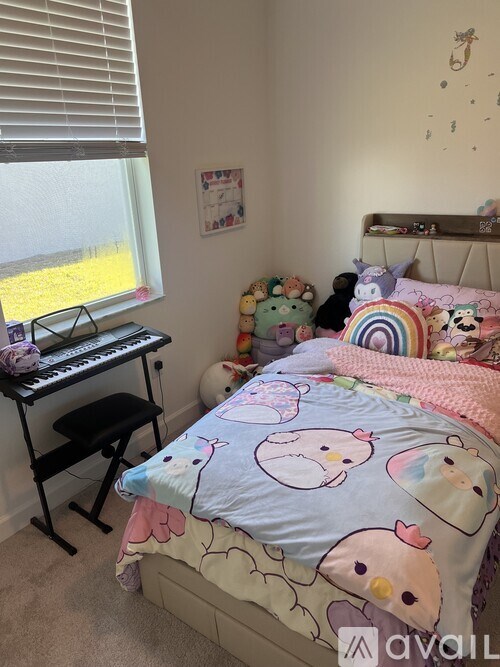 A child's bedroom with a bed, a desk with a keyboard, and a window with blinds.