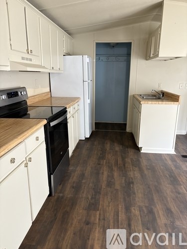 A kitchen with white cabinets and a black stove top oven.