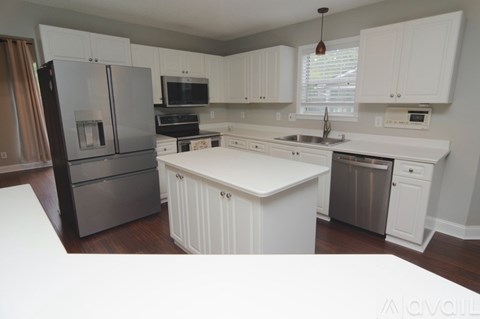 A kitchen with white cabinets and appliances.
