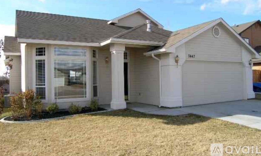 A white house with a grey roof and a garage door.