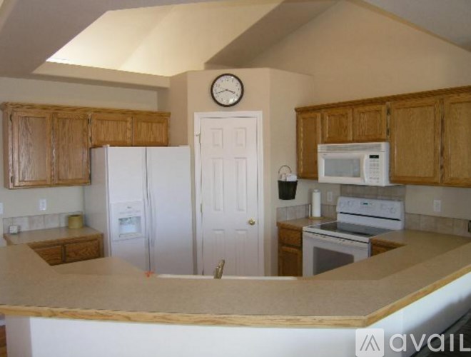 A kitchen with wooden cabinets and a white refrigerator.