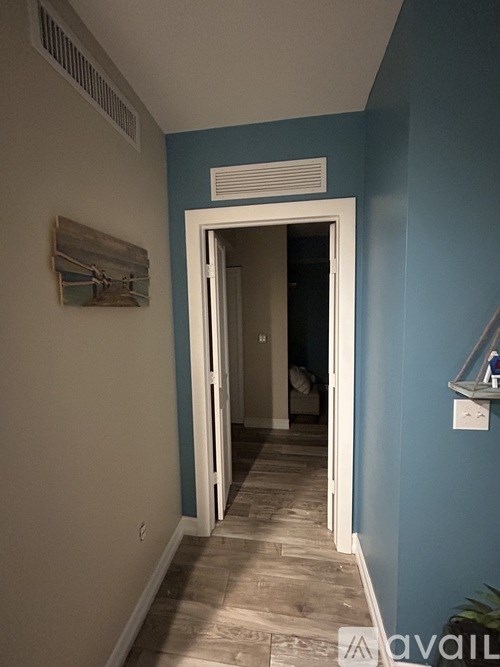 A hallway with a doorway leading to another room.