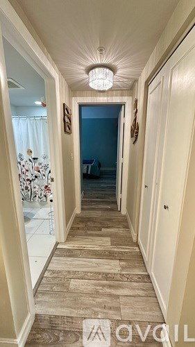 A room with a white door open to a kitchen.