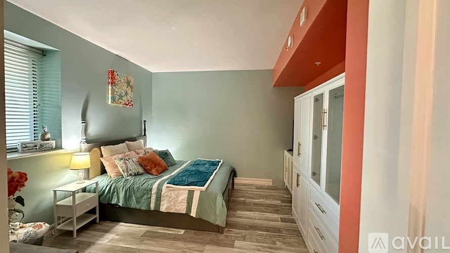 A hallway with a light fixture and a wooden decoration on the wall.