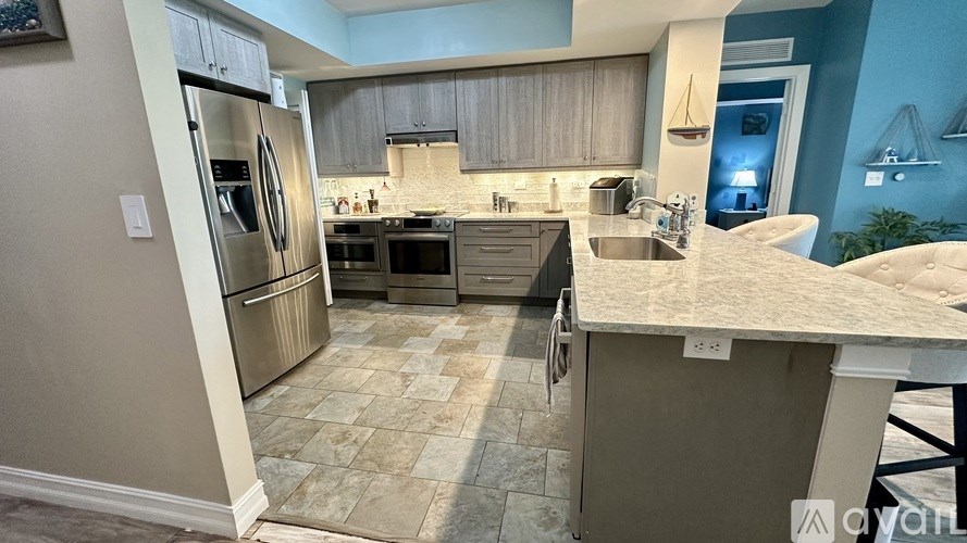 A hallway with a large painting on the wall and a person walking in the distance.