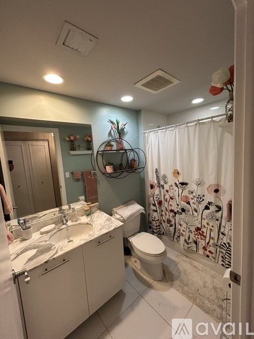 A bathroom with a sink, toilet, and shower.
