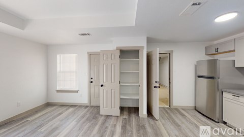 A kitchen with white cabinets and a wooden floor.