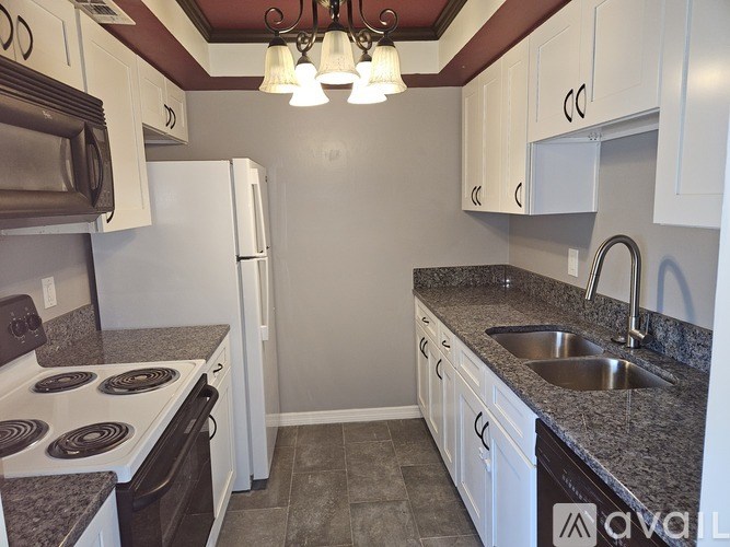 A kitchen with white cabinets and a granite counter top.