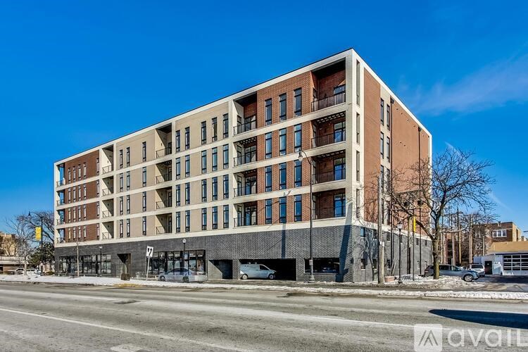 A large, modern apartment building with balconies on the upper floors.
