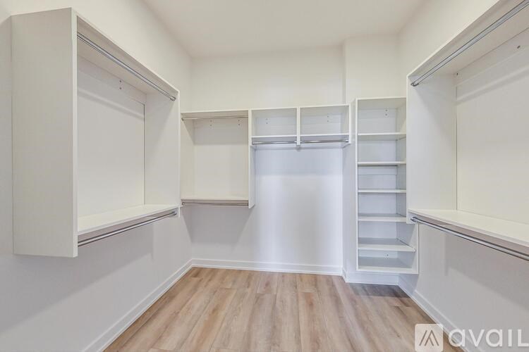 A white pantry with wooden floors and white cabinets.