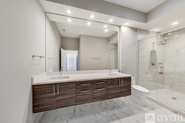 A modern bathroom with a marble floor and a walk-in shower.