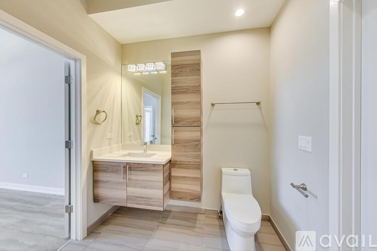 A bathroom with a toilet, sink, and mirror.