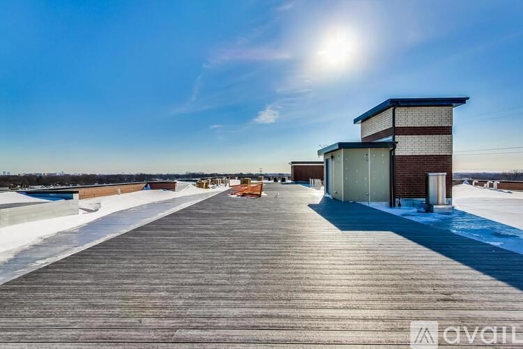 A sunny day at an outdoor location with a wooden deck and buildings in the background.