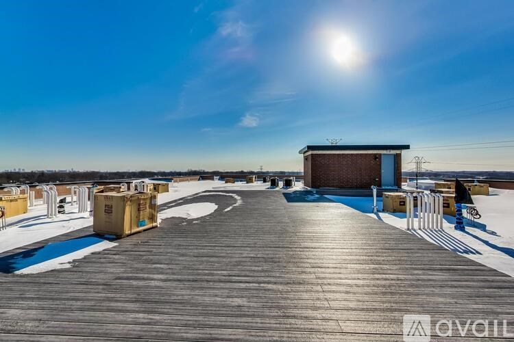 A wooden boardwalk with a building and containers on the left side.