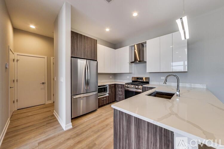A modern kitchen with a marble countertop and stainless steel appliances.